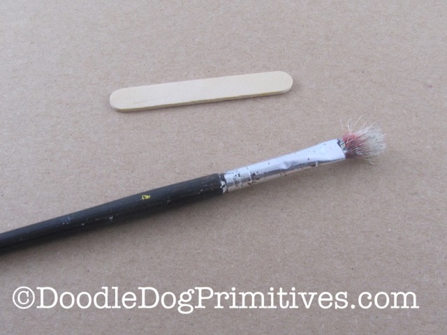 Paint brush and popsicle stick to use in splattering the eggs with paint